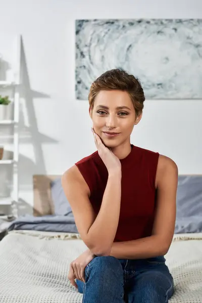A young woman in a red tank top relaxes at home, embodying a casual lifestyle with a serene expression. — Stock Photo