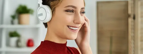 Bright smile on face of a young woman enjoys her favorite tunes in a cozy home setting. — Stock Photo