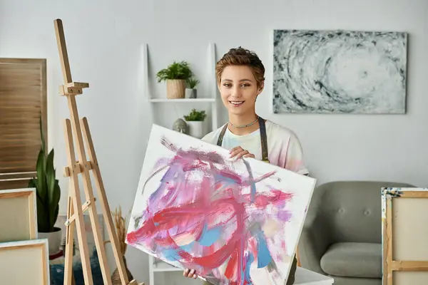 In a cozy home studio, a young woman joyfully expresses herself through painting, showcasing her talent. — Stock Photo