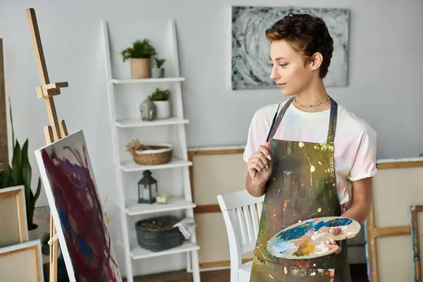 A creative young woman immerses herself in painting, showcasing her artistic talent at home. — Stock Photo