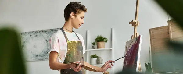 Una joven talentosa crea una pintura expresiva en casa, disfrutando de su arte y pasatiempo en paz. - foto de stock