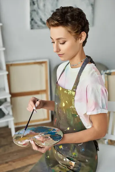 Inside her cozy home, a young woman expresses her creativity by painting a vibrant picture with passion. — Stock Photo