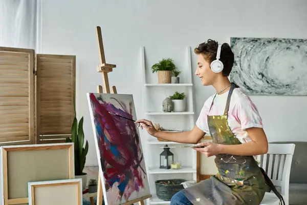 Una joven con maquillaje natural se sumerge en la pintura en casa, encontrando alegría en su expresión artística. - foto de stock