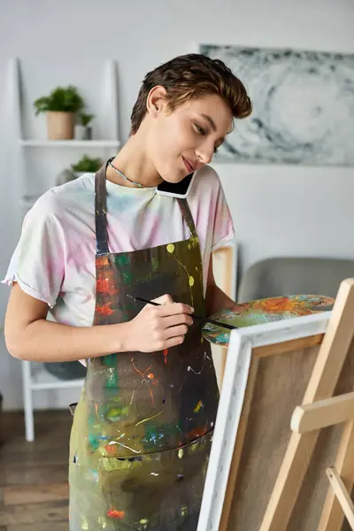 A young woman with natural makeup engages in painting, expressing her artistic talent in a serene home setting. — Stock Photo