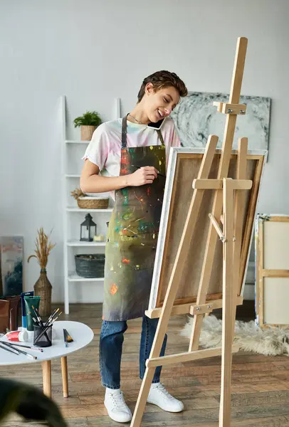 In a bright and inviting home studio, a young woman expresses her creativity while painting and smiling. — Stock Photo