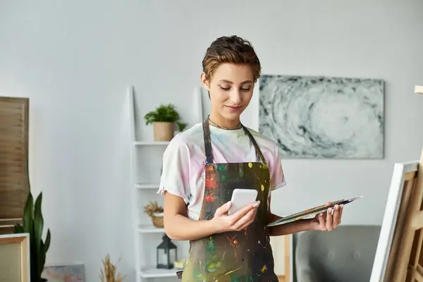 Zu Hause mischt eine junge Frau Farben und lässt sich beim Malen ihrer neuesten Kreation inspirieren. — Stockfoto