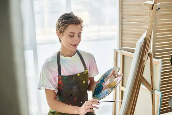 Bright light fills the room as a young woman paints joyfully, expressing her creativity on canvas. — Stock Photo