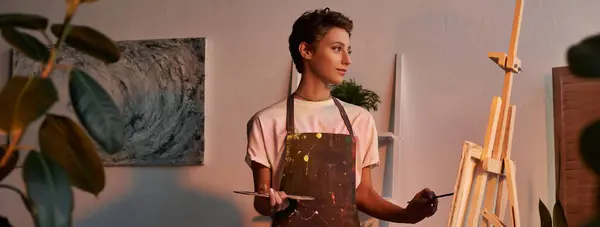 A passionate young woman stands in her cozy home, immersed in painting as evening light surrounds her. — Stock Photo