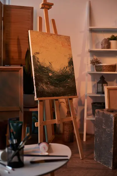 Ocean painting on canvas and easel in art studio during golden hours in evening time — Stock Photo