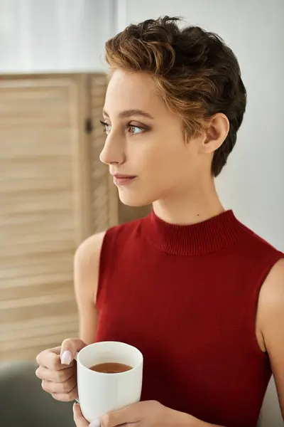 A young woman in a red tank top embracing her everyday lifestyle at home. — Stock Photo