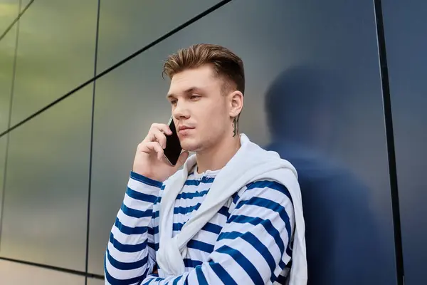 Un joven elegante con una pierna protésica se involucra en una conversación telefónica, mostrando resiliencia. - foto de stock