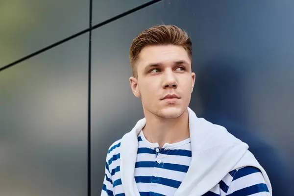 Ein selbstbewusster junger Mann mit Beinprothese, der vor einem eleganten Hintergrund seinen persönlichen Stil zeigt. — Stockfoto