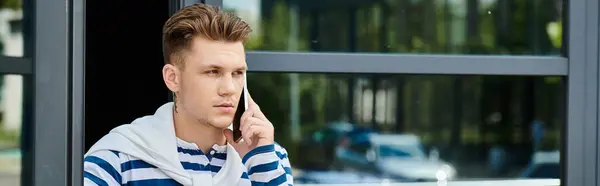 A handsome young man with a prosthetic leg engages in an important phone call outside. — Stock Photo