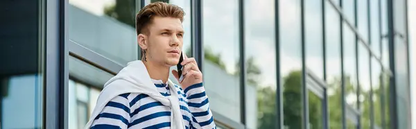 Ein junger Mann mit Beinprothese steht nachdenklich neben gläsernen Gebäuden. — Stockfoto