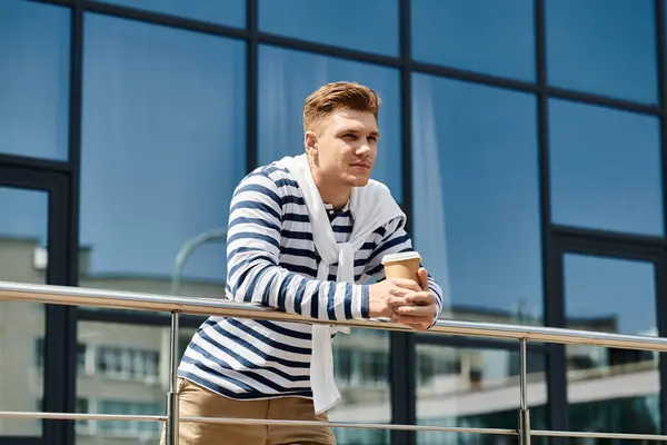 A young, handsome man with a prosthetic leg relaxes while sipping coffee on a sunny day. — Stock Photo