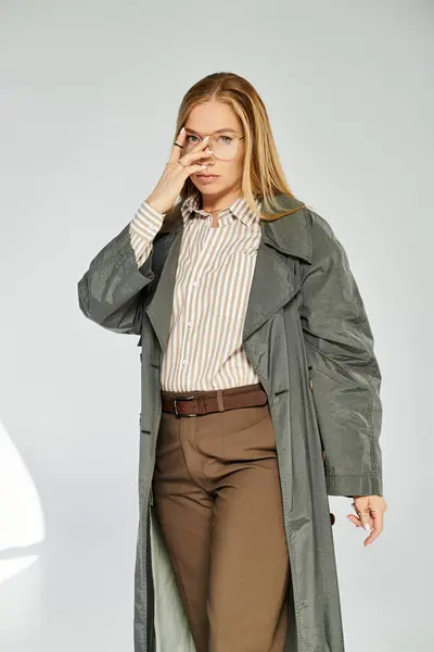 Una donna elegante con modelli di capelli lunghi abbigliamento autunno alla moda, trasudando fiducia e grazia. — Foto stock