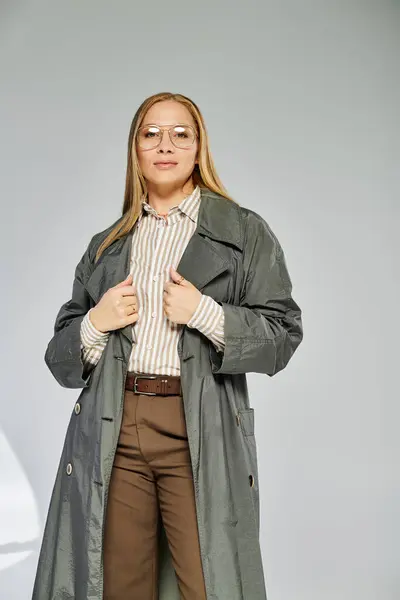 A confident woman with long hair showcases her autumnal fashion in a chic studio environment. — Stock Photo