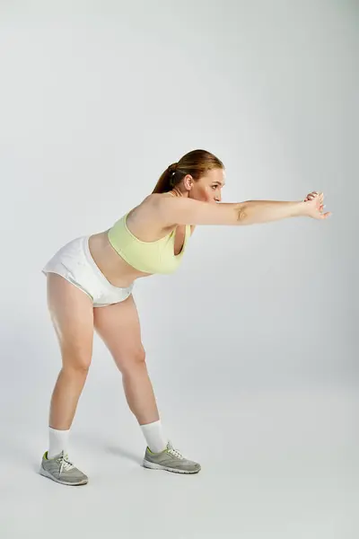 Una deportista dedicada se centra en su rutina de ejercicios en un ambiente de estudio vibrante. - foto de stock