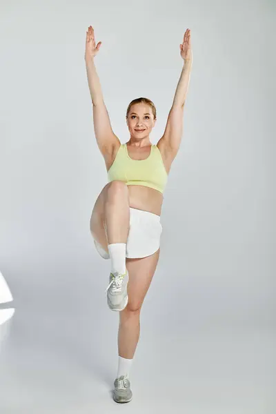 Engaged in a lively workout, a fit woman showcases her strength and agility in a bright studio. — Stock Photo
