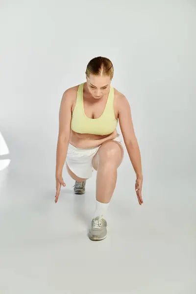 A dedicated sportswoman exercises with lunges in a vibrant studio, showcasing her focus and commitment. — Stock Photo