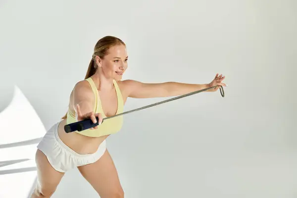 A vibrant woman engages in an energetic workout, showcasing her strength in a stylish crop top. — Stock Photo