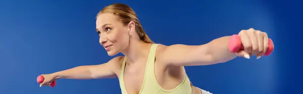 A fit and energized woman engages in an intense workout, showcasing her dedication and strength training. — Stock Photo