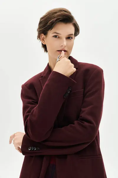 A stylish woman in winter attire radiates confidence while striking a poised pose indoors. — Stock Photo