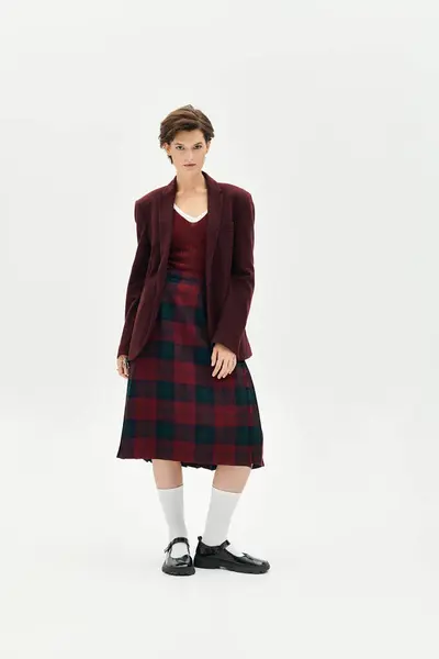 A stylish woman confidently displays her elegant winter outfit in a minimalist setting. — Stock Photo