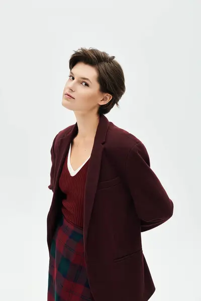 Embracing the warmth of winter, a woman showcases her elegant attire in a cozy indoor atmosphere. — Stock Photo