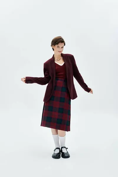 A chic woman poses gracefully in warm, fashionable winter attire inside a minimalist setting. — Stock Photo