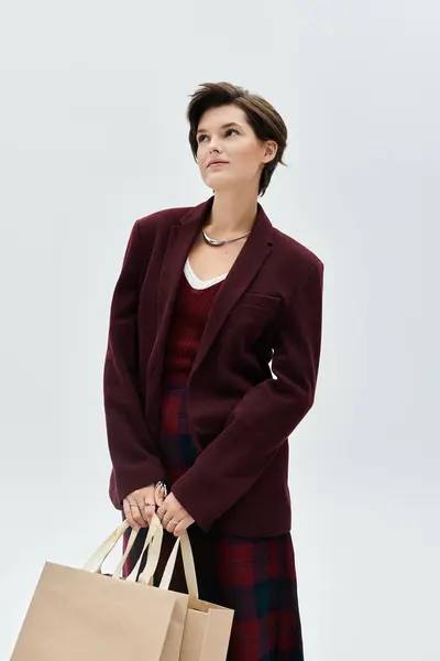A stylishly dressed woman showcases her winter fashion while holding shopping bags. — Stock Photo