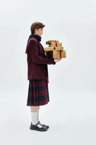 A stylishly dressed woman carries wrapped gifts, embodying the holiday spirit. — Stock Photo