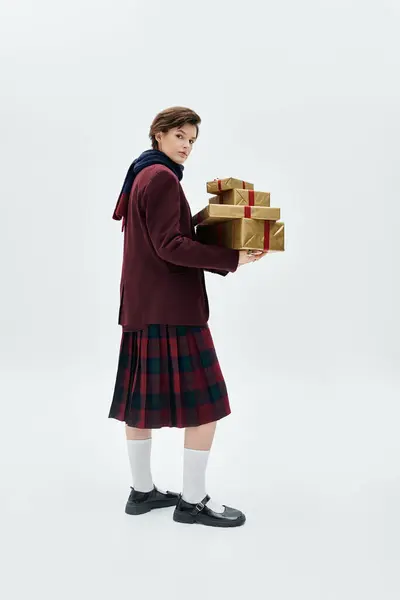 A woman in cozy winter attire holds elegant, beautifully wrapped gifts. — Stock Photo