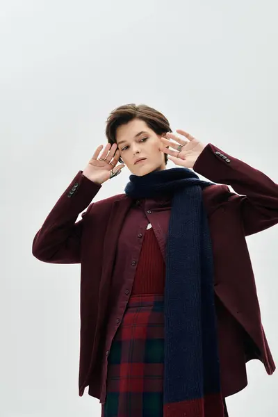 A beautiful woman showcases her stylish winter outfit while striking a serene pose. — Stock Photo