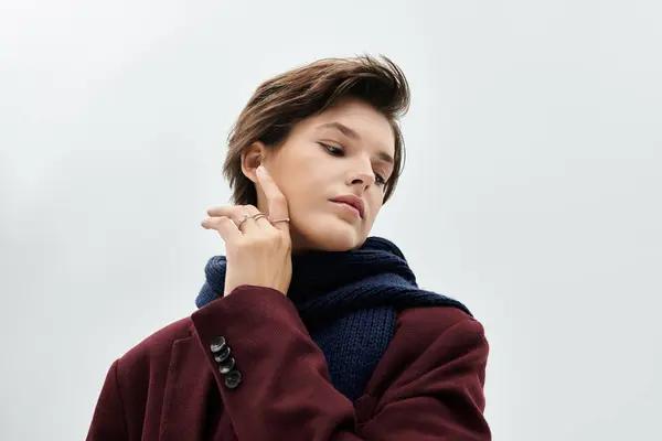 A beautiful woman showcases her stylish winter outfit while gently touching her face. — Stock Photo