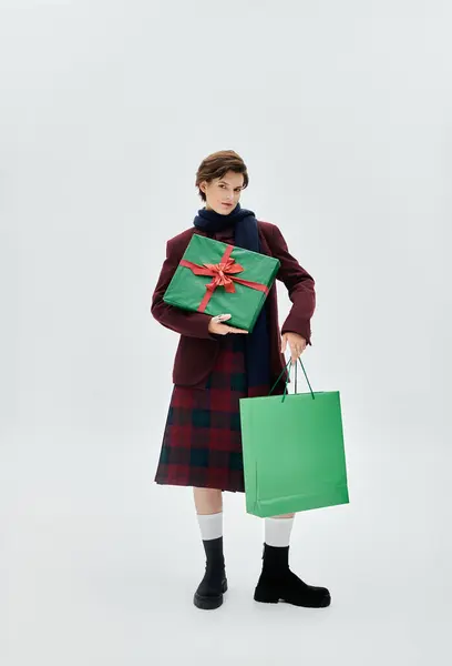 Dressed in elegant winter style, she showcases Christmas gifts, capturing the festive spirit. — Stock Photo