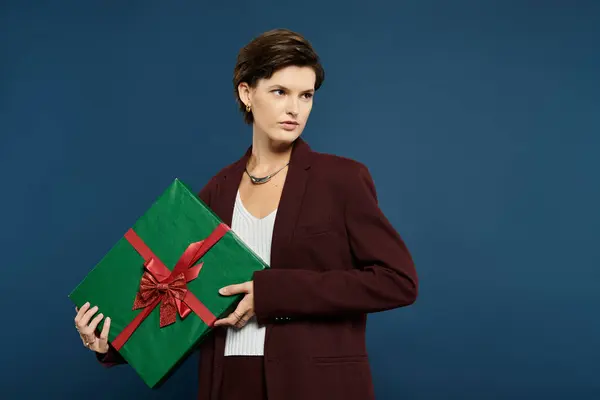A beautiful woman showcases cozy winter attire, holding a beautifully wrapped gift. — Stock Photo