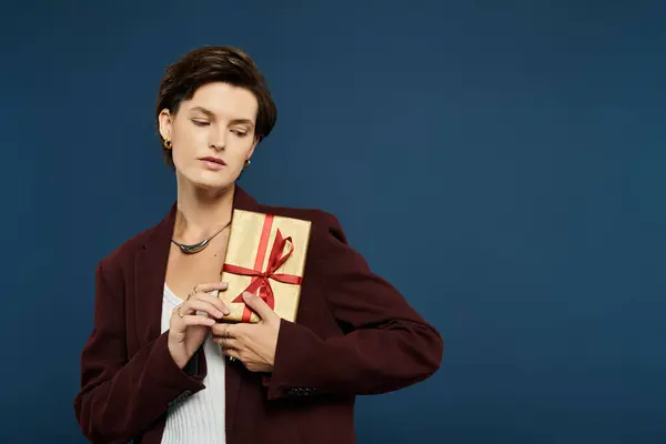 A stylish woman in cozy winter fashion cradles an elegant gift while lost in contemplation. — Stock Photo