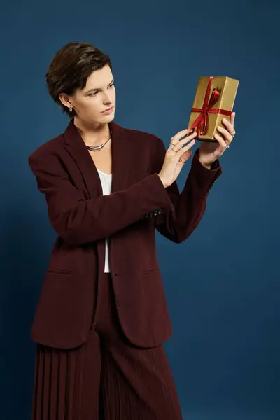 Eine schön gekleidete Frau bewundert ein Geschenk und präsentiert ihre stylische Wintermode und Intrigen. — Stockfoto