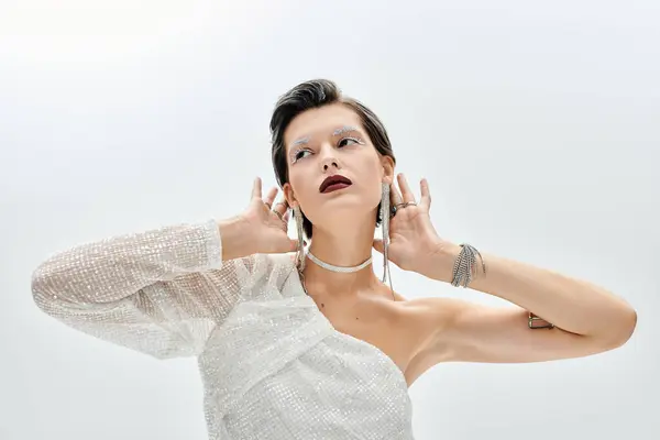 Una mujer llamativa posa pensativamente, su elegante atuendo de invierno refleja sofisticación y calidez. - foto de stock