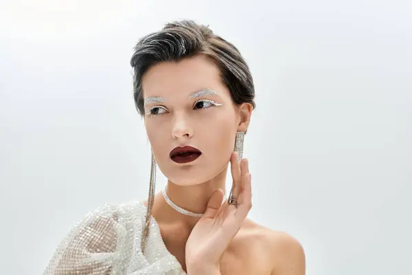 In kuscheliger Winterkleidung verkörpert eine atemberaubende Frau Eleganz vor weichem Hintergrund. — Stockfoto