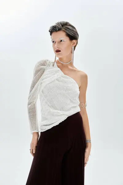 A beautiful woman in chic winter attire exudes elegance against a soft background, captivating all. — Stock Photo