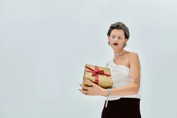 An elegant winter dressed woman presents a lovely gift, radiating warmth and joy. — Stock Photo