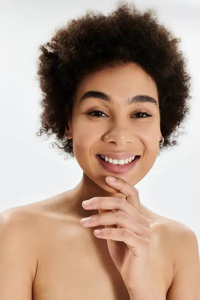 Uma jovem alegre posa com um sorriso atencioso, mostrando sua beleza natural em uma luz suave. — Fotografia de Stock