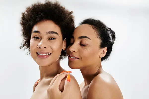 Two women embrace, showcasing their beauty with confident smiles and playful expressions. — Stock Photo