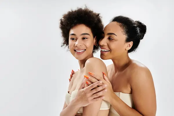 Two friends express happiness in a warm, friendly embrace and share genuine smiles together. — Stock Photo