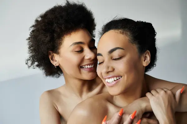 Two sisters embrace, radiating happiness and warmth, surrounded by soft lighting. — Stock Photo