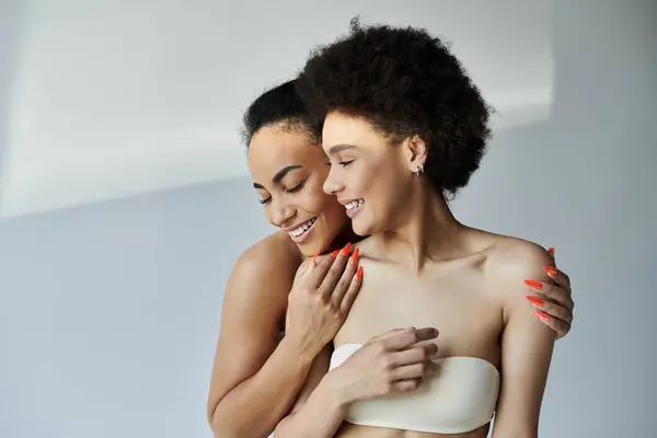 Two women share a warm moment, smiling and enjoying each others company together. — Stock Photo