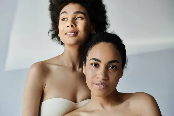 Um retrato caloroso e íntimo de duas mulheres desfrutando de um vínculo próximo em um espaço iluminado suave. — Fotografia de Stock