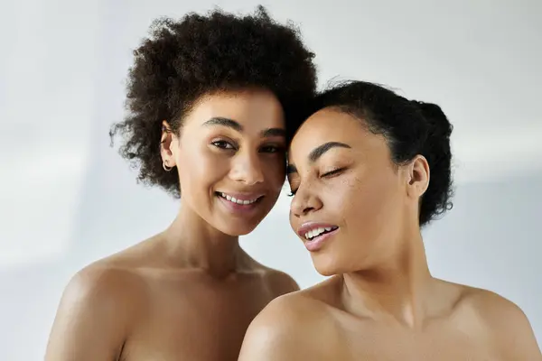 Two women share a joyful moment, radiating confidence and grace in a tranquil atmosphere. — Stock Photo